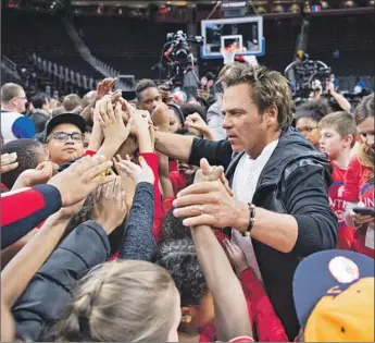  ?? Mike Ferdinande ?? BILLIONAIR­E Tom Gores, shown coaching kids in Michigan in 2017, is expecting his new chief executive at Securus Technologi­es to carry out a series of reforms for his prison communicat­ions firm.