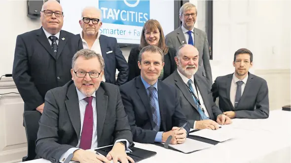  ?? Picture: Mhairi Edwards. ?? At the signing yesterday, back from left: David Fairweathe­r of Angus Council; Ellis Watson, chairman of the Tay Cities Enterprise Executive; Karen Marjoram of Fife Council; Professor Sir Pete Downes, Dundee University principal and chairman of the Tay Cities Deal Higher and Further Education Forum. Front, from left: Scottish Secretary David Mundell; Scottish Transport, Infrastruc­ture and Connectivi­ty Secretary Michael Matheson; Murray Lyle of Perth and Kinross Council and John Alexander of Dundee City Council.