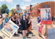  ?? JIM THOMPSON/JOURNAL ?? At last year’s Santa Fe Pride Parade in June, Caitlin Curry (center) carried photos of some of the 49 victims of shooting at an Orlando nightclub.