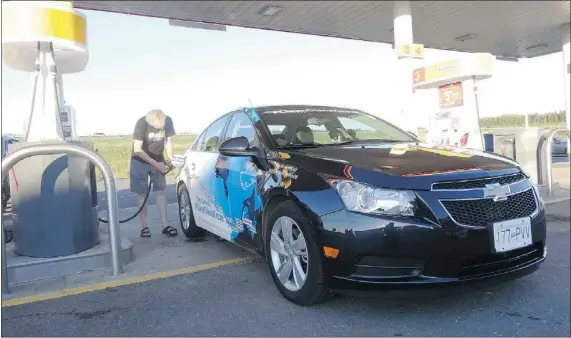  ?? LISA CALVI/FOR THE PROVINCE ?? Lisa’s husband Garry Sowerby fuels up the 2014 Chevy Cruze Clean Turbo Diesel just outside of Edmundston, N.B. That fuel stop was the last on the couple’s journey across Canada. After 5,956 kms, their average overall fuel economy was 4.21 L/100 km.