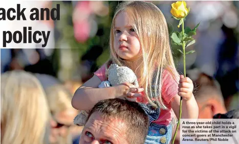  ??  ?? A three-year-old child holds a rose as she takes part in a vigil for the victims of the attack on concert goers at Manchester Arena. Reuters/Phil Noble