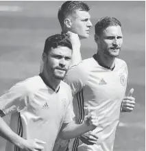  ?? PATRIK STOLLARZ/AFP/GETTY IMAGES ?? Germany’s players warm up before practice on the eve of the team’s Euro 2016 quarter-final match against Italy. The Germans have never beaten Italy at a major tournament.