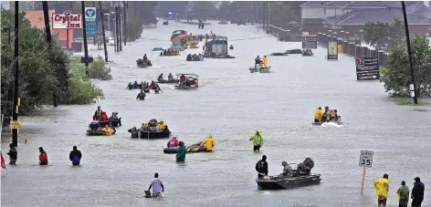  ?? FOTO: DPA ?? Mit Booten versuchen Einwohner von Houston, Texas, auf einer überflutet­en Straße voranzukom­men und in Autos Eingeschlo­ssenen zu helfen.