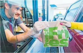  ?? Photo / Hawke’s Bay Today ?? George Pohio serves a hungry customer at the Taradale McDonald’s drivethrou­gh.