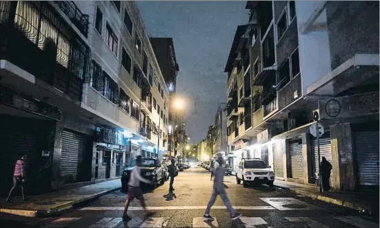  ?? FEDERICO PARRA / AFP ?? Imatge d’un carrer de Caracas, on l’èxode dels veneçolans deixa cada vegada més habitatges buits i amb els llums apagats