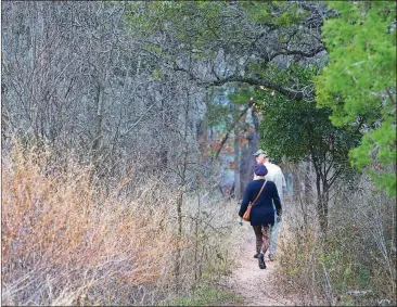  ?? RALPH BARRERA / AMERICAN-STATESMAN ?? Mayfield Preserve, a 21-acre natural area that surrounds Mayfield Park, features walking trails and wildlife habitats. A couple is pictured hiking in the nature preserve.