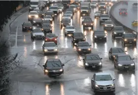  ?? Michael Macor / The Chronicle ?? Vehicles navigate through the flooded lanes on northbound Highway 101 near Cesar Chavez Street in San Francisco. The storms caused traffic havoc around the Bay Area and beyond. Motorists were especially cautioned about driving in the Sierra.