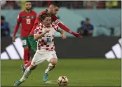  ?? FRANK AUGSTEIN — THE ASSOCIATED PRESS ?? Croatia’s Luka Modric, front, duels for the ball with Morocco’s Hakim Ziyech during the World Cup third-place playoff match at Khalifa Internatio­nal Stadium in Doha, Qatar, on Saturday.