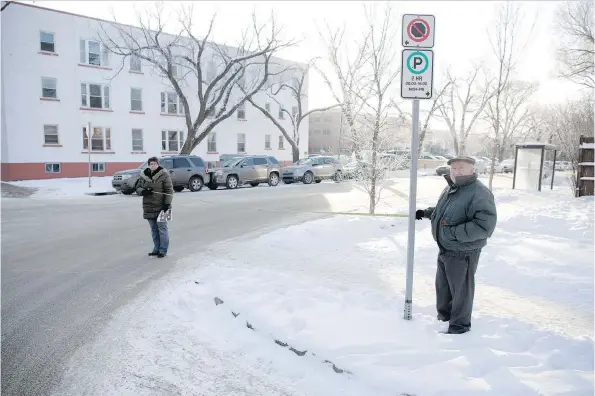  ?? TROY FLEECE ?? Dawn Ridgway, left, and John Perdicaris hold a tape measure on the corner of 14th Avenue and Halifax Street in Regina. The distance from the signpost is about five metres, far less than the 10 metres the city bylaw allows vehicles to be parked from a...