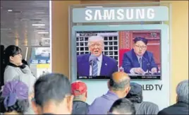  ?? AP ?? Commuters at the Seoul railway station watch images of US President Donald Trump and North Korean leader Kim Jong Un during a news programme on Tuesday.