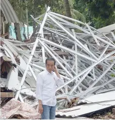  ??  ?? Indonesian President Joko Widodo looks on near the collapsed Hotel Mutiara Carita after it was hit by a tsunami in Pandeglang, Banten province. — Reuters photo