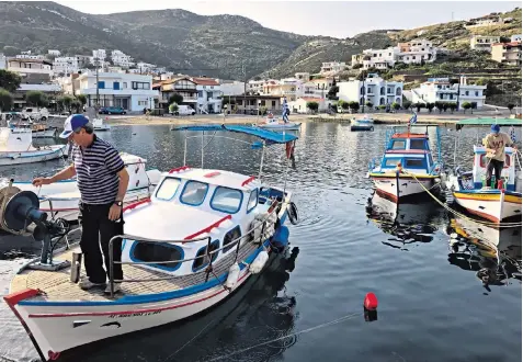  ??  ?? Life goes on as normal on Greece’s Aegean islands. Left, army recruits land on the island of Kastellori­zo last month as incidents with Turkey increase