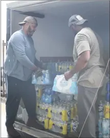  ?? Brodie Johnson • Times-Herald ?? The City of Forrest City gathered a large amount of water to be donated to the City of Eudora amid an emergency situation within that city. Anthony Crippen, left, and Kim McLaurin load a trailer with water donations that were being delivered to the city.