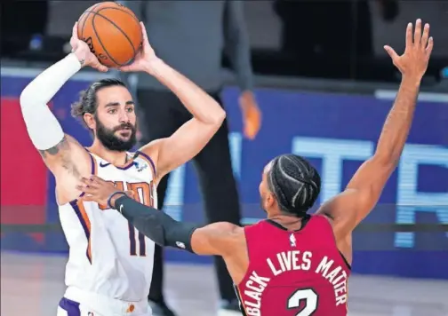  ??  ?? Ricky Rubio, de Phoenix, trata de pasar ante Gabe Vincent, de Miami.