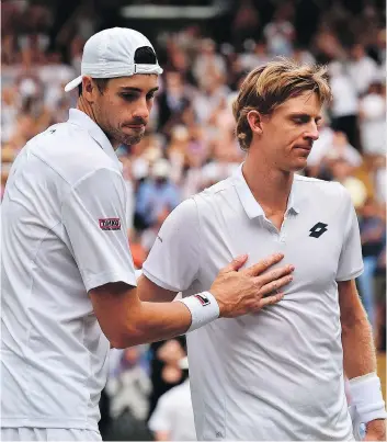  ?? GLYN KIRK/THE ASSOCIATED PRESS ?? American John Isner, left, meets up with Kevin Anderson of South Africa at the net following their epic five-set semifinal match on Friday at Wimbledon. Anderson prevailed in what is now the second-longest match in the history of a tournament that...