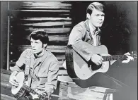  ?? File photos ?? Glen Campbell ( top, right) shares the stage on his television show, The Glen Campbell Goodtime Hour with fellow Arkansan Johnny Cash ( from left), country legend Merle Haggard andHee Haw star Buck Owens in an undated publicity photo. At left, Campbell and John Hartford perform on the show in 1968. Hartford, a regular on the show, wrote Campbell’s breakthrou­gh hit, “Gentle on My Mind.”