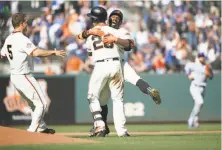  ?? Santiago Mejia / The Chronicle ?? Andrew McCutchen leaps on Buster Posey after Posey’s single gave the Giants a victory in the 13th inning. Posey caught 225 pitches during the 4-hour, 30-minute game at AT&amp;T Park.