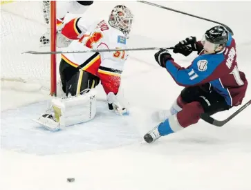 ?? Barry Gutierrez/The Associated Press ?? Flames goalie Karri Ramo watches as Colorado Avalanche’s Jamie McGinn misses the puck in front of the net during the first period on Friday in Colorado.