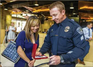  ?? PHOTOS BY STEPHEN SPILLMAN / FOR AMERICAN-STATESMAN ?? Thuy Ho-Ellsworth views the Medal of Valor given to her husband, Sgt. Brannon Ellsworth, Thursday at Austin City Hall for his work in the March bombings.