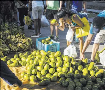  ?? Desmond Boylan The Associated Press ?? People shop at an outdoor food market Saturday in Havana. Cuban lawmakers on Saturday approved the Cabinet named by new President Miguel Diaz-Canel.