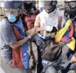  ?? EFE ?? Víctima. Un grupo de manifestan­tes auxilia al joven David José Vallenilla, luego de recibir un disparo de un miembro de la Guardia Nacional.