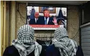  ?? Ahmad Gharabli / AFP|Getty Images ?? Palestinia­n men watch an address given by President Donald Trump at a cafe in Jerusalem on Wednesday.