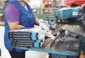  ?? Bloomberg ?? An employee uses a drill press to add holes to books at a facility in Ontario, Canada.