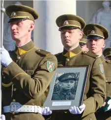  ??  ?? A picture taken on Oct 6, 2018 shows a military guard holding a portrait of the commander of the 1944-1953 partisan resistance movement against Soviet occupation, Adolfas Ramanauska­s during a state funeral in Vilnius, Lithuania.