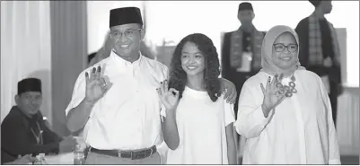  ?? HENDRA EKA/JAWA POS ?? MENANG: Anies Baswedan (kiri) didampingi istri Fery Farhati Ganis (kanan) dan anak Mutiara Annisa Baswedan di TPS 28 Cilandak Barat kemarin.