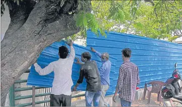  ?? DEEPAK GUPTA/HT ?? Corrugated metal sheets being placed to block view of cremations at Bhainsakun­d in Lucknow on Thursday.