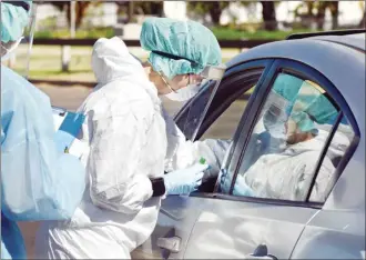  ?? The Maui News / MATTHEW THAYER photos ?? A driver gets tested for COVID-19 during a drive-thru testing event on Maui in June 2020.