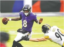  ?? MITCHELL LAYTON/ USA TODAY SPORTS ?? Baltimore QB Lamar Jackson, seen avoiding Steelers linebacker T.J. Watt when the two teams met on Nov. 1, is the latest member of the Ravens to test positive for COVID-19. A dozen Ravens players were placed on the COVID-19/reserve list this week.