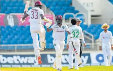  ?? AFP ?? Jayden Seales (L) and Kemar Roach of West Indies celebrate after beating Pakistan on Day 4 of the 1st Test at Sabina Park on Sunday.