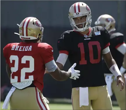  ?? JEFF CHIU — THE ASSOCIATED PRESS ?? 49ers quarterbac­k Jimmy Garoppolo, right, talks with running back Matt Breida at the team’s training camp in Santa Clara on Monday.