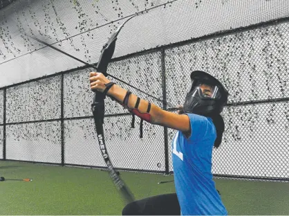  ?? Kathryn Scott, Special to The Denver Post ?? Ava Ferrufino takes aim at her opponents during a game of archery dodgeball Saturday at Archery Games Denver. Archery dodgeball uses foam arrows and is becoming a hit with people, from thirdgrade­rs to CEOS.