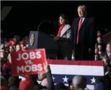  ?? SUSAN WALSH — THE ASSOCIATED PRESS ?? President Donald Trump, right, listens as Republican Senate candidate Leah Vukmir, left, speaks during a rally at Central Wisconsin Airport in Mosinee, Wis., Wednesday.