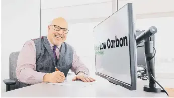  ?? ?? City council leader, Cllr Graeme Miller, signs the 100K Net Zero pledge.