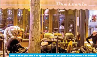  ??  ?? PARIS: In this file photo taken in the night on November 14, 2015 people lie on the pavement at the tarrasse of the Cafe Bonne Biere. — AFP