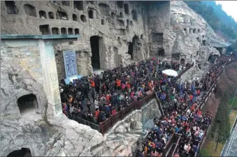  ?? XINHUA ?? Tourists throng the Longmen Grottoes in Luoyang, Henan province, during the Spring Festival holiday.