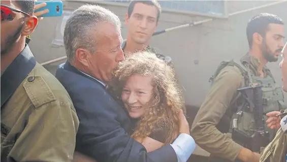  ?? AP ?? Emoción. Tamimi que tiene sólo 17 años se abraza a su padre después de su liberación. La chica se reunió ayer con el presidente palestino.