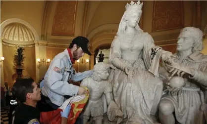  ??  ?? A demonstrat­or is removed from the statue of Queen Isabella and Christophe­r Columbus in the rotunda of the capitol in Sacramento, California, in 2018. Photograph: Rich Pedroncell­i/AP