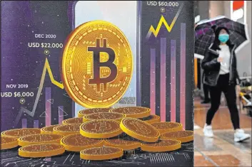  ?? Kin Cheung The Associated Press file ?? A Bitcoin cryptocurr­ency advertisem­ent is featured on a Hong Kong street in February 2022. The world’s largest cryptocurr­ency soared to almost $35,000 this week.