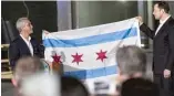  ??  ?? Mayor Rahm Emanuel presents Elon Musk with a Chicago flag after Musk’s business The Boring Company won a bid to build an undergroun­d system connecting downtown and O’Hare.
