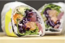  ?? RANDY RISLING/TORONTO STAR ?? Wrapped in nori and a layer of sticky rice, the samurachi burrito is stuffed with a bright assortment of vegetables and raw fish.