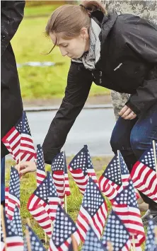  ?? STAFF FILE PHOTOS BY PATRICK WHITTEMORE ?? IN MEMORIAM: Melissa Curtis, above, of Westboro, plants a flag in honor of her late brother, Army Ranger Christophe­r Dona, during the Rememberin­g and Honoring Our Massachuse­tts Heroes event last Thursday on Boston Common. In the top photo at left,...