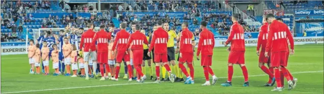  ??  ?? Los jugadores del Atlético saludan a los del Alavés y a los colegiados antes del inicio del encuentro jugado ayer en Vitoria.