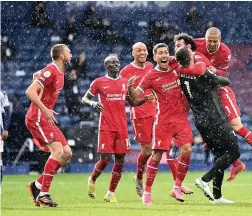  ?? LAURENCE GRIFFITHS/PA ?? INCREDIBLE FINISH: Liverpool goalkeeper Alisson is mobbed by his team-mates after heading an injury time winner from a corner