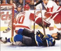  ?? TOM GANNAM/ AP ?? Detroit goalie Chris Osgood follows the puck and ignores Blues’ Dallas Drake as he slides into the net yesterday. Detroit won 4- 1.