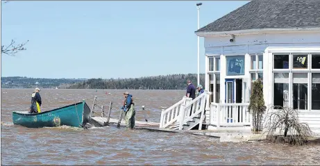  ?? CP PHOTO ?? Sailors prepare to secure a work boat at the Royal Kennebecas­is Yacht Club in Saint John, N.B. on Saturday, May 5, 2018. Swollen rivers across New Brunswick are still rising, flooding streets and properties and forcing people from their homes in...