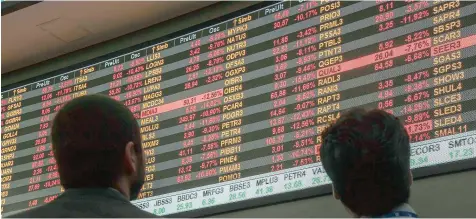  ?? — AFP ?? Visitors look at an electronic board at the Sao Paulo Stock Exchange (B3), in Sao Paulo, Brazil.